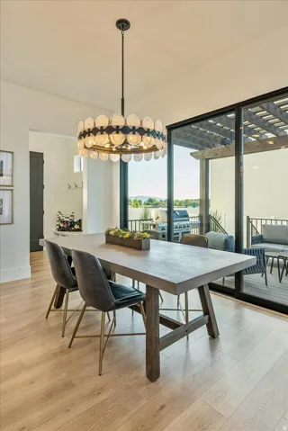 Dining space with plenty of natural light, a chandelier, and light wood-type flooring