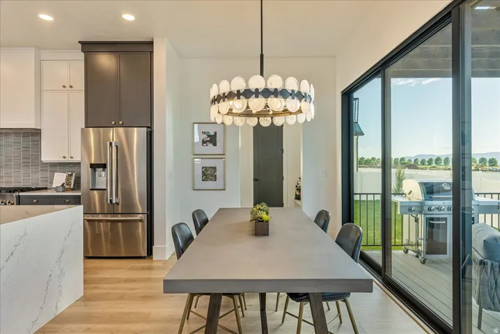 Dining space with light wood-style floors, recessed lighting, and a chandelier