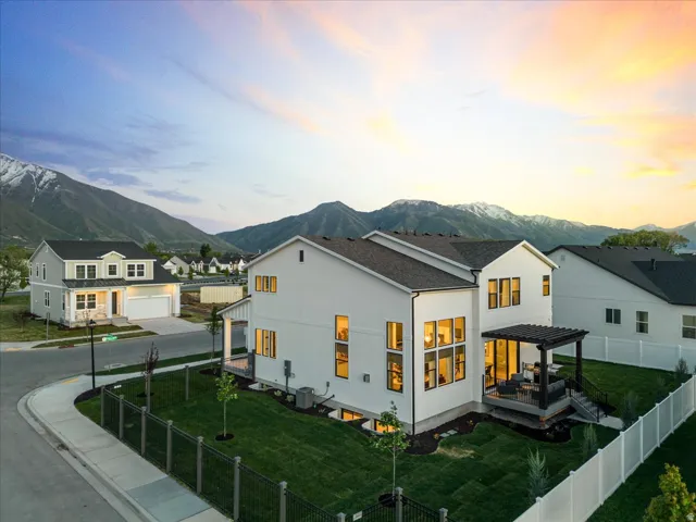 Back of property with a fenced backyard, a pergola, stucco siding, and a deck with mountain view