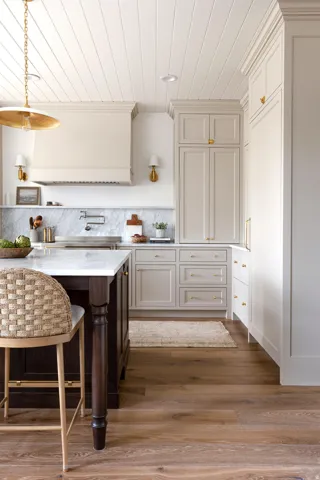 Kitchen with dark wood-type flooring, light stone counters, open shelves, custom exhaust hood, and a breakfast bar