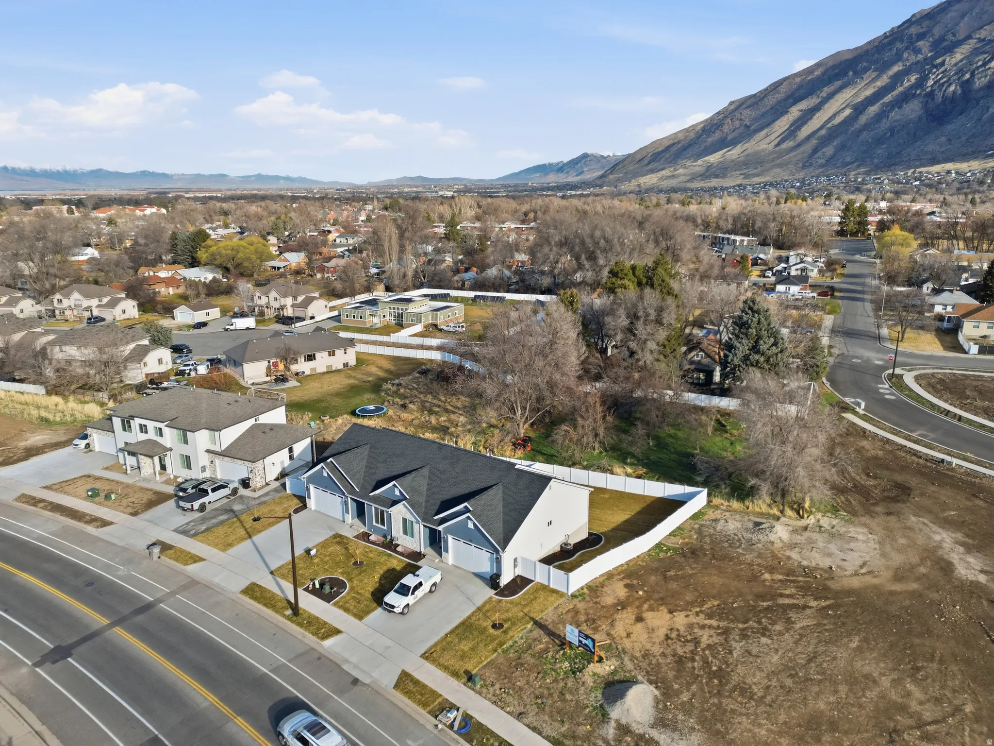 Aerial view of property and surrounding area with nearby suburban area and a mountainous background