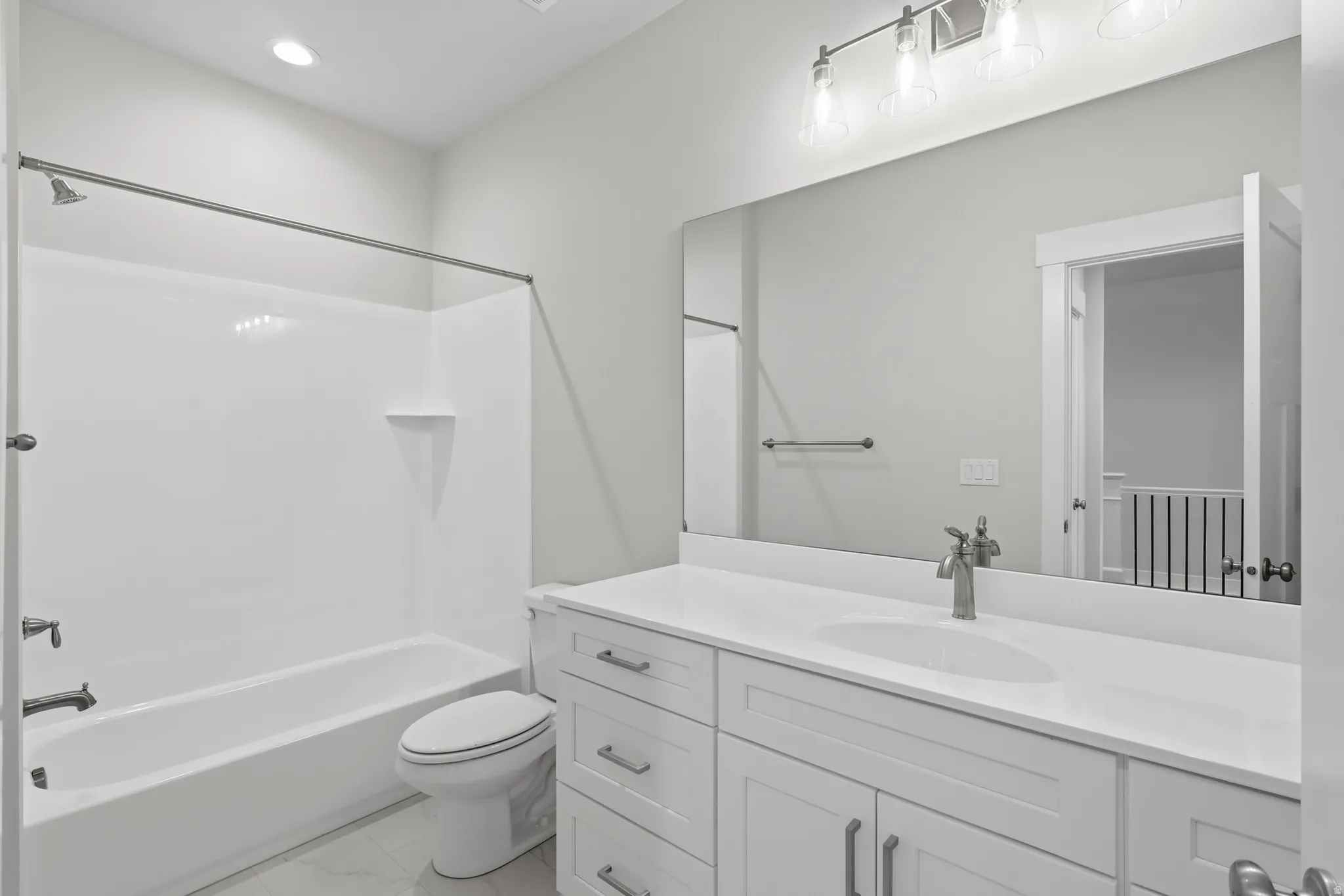 Bathroom with vanity, shower / tub combination, light marble finish flooring, and recessed lighting