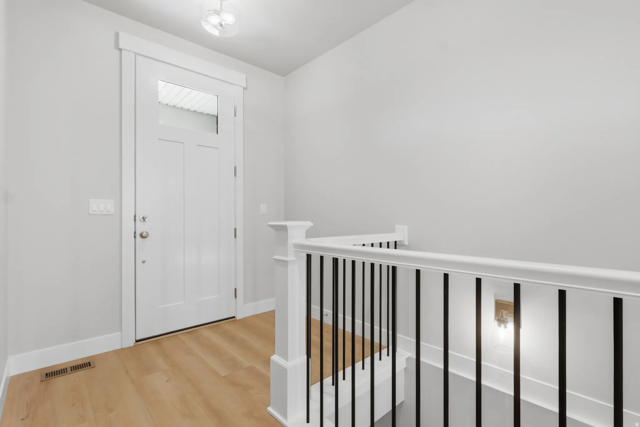 Entryway with light wood-style floors and baseboards
