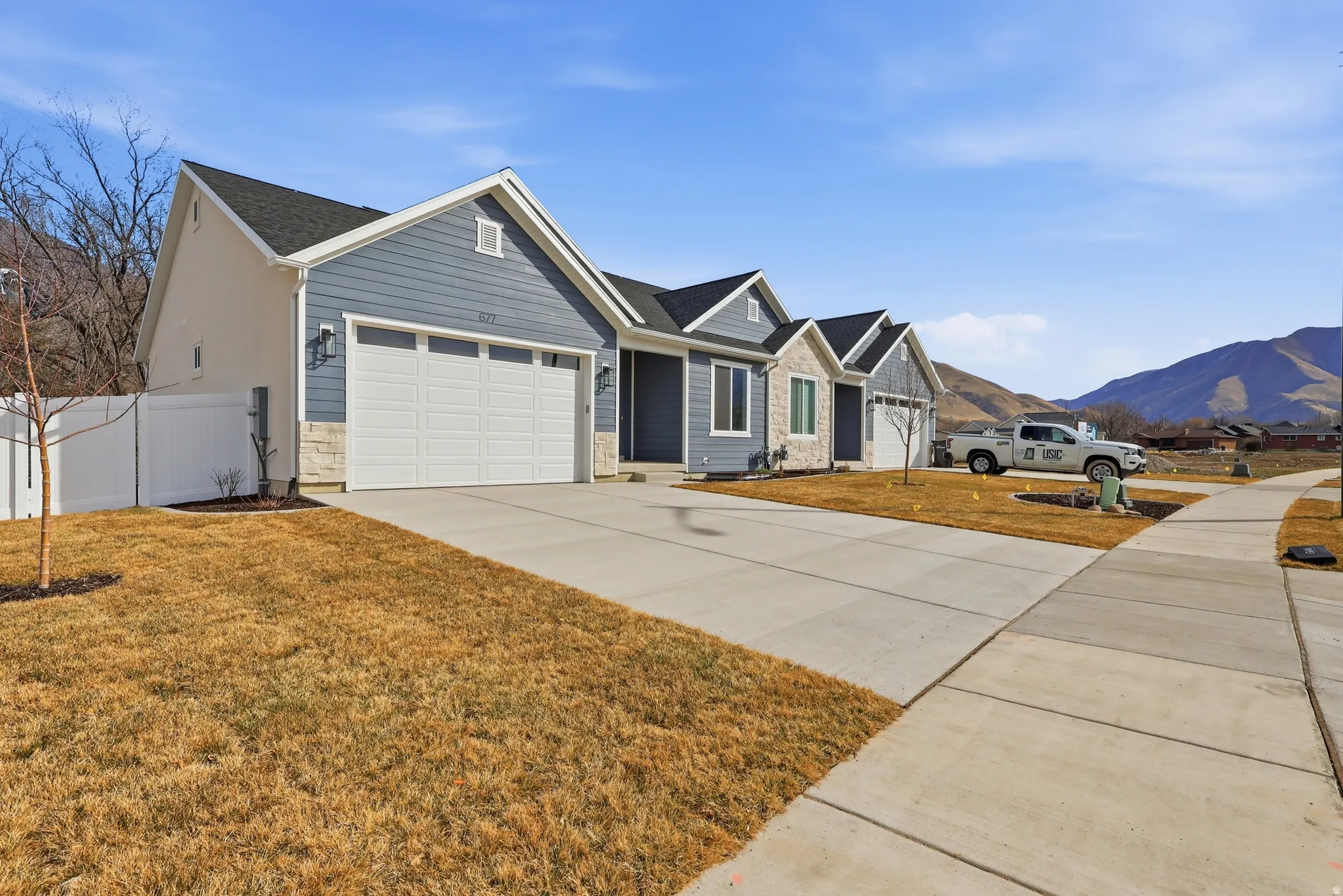 Ranch-style home featuring a mountain view, a garage, and driveway