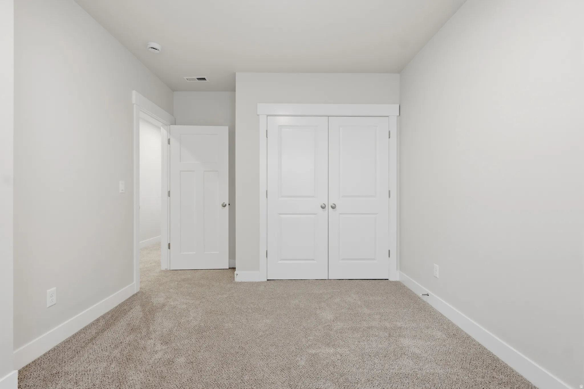 Unfurnished bedroom featuring light colored carpet and a closet