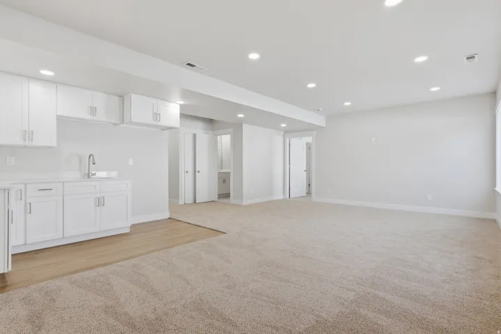 Unfurnished living room featuring light colored carpet and recessed lighting