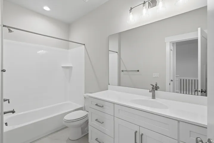 Bathroom with vanity, shower / tub combination, light marble finish flooring, and recessed lighting