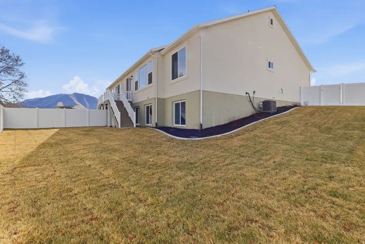 Rear view of property with a fenced backyard, stucco siding, and a wooden deck