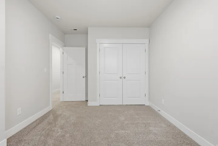 Unfurnished bedroom featuring light colored carpet and a closet
