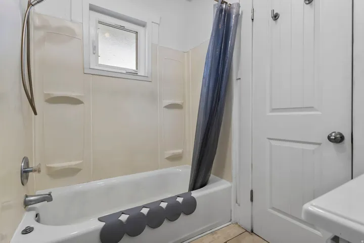 Bathroom featuring shower / bathtub combination with curtain and light tile patterned floors