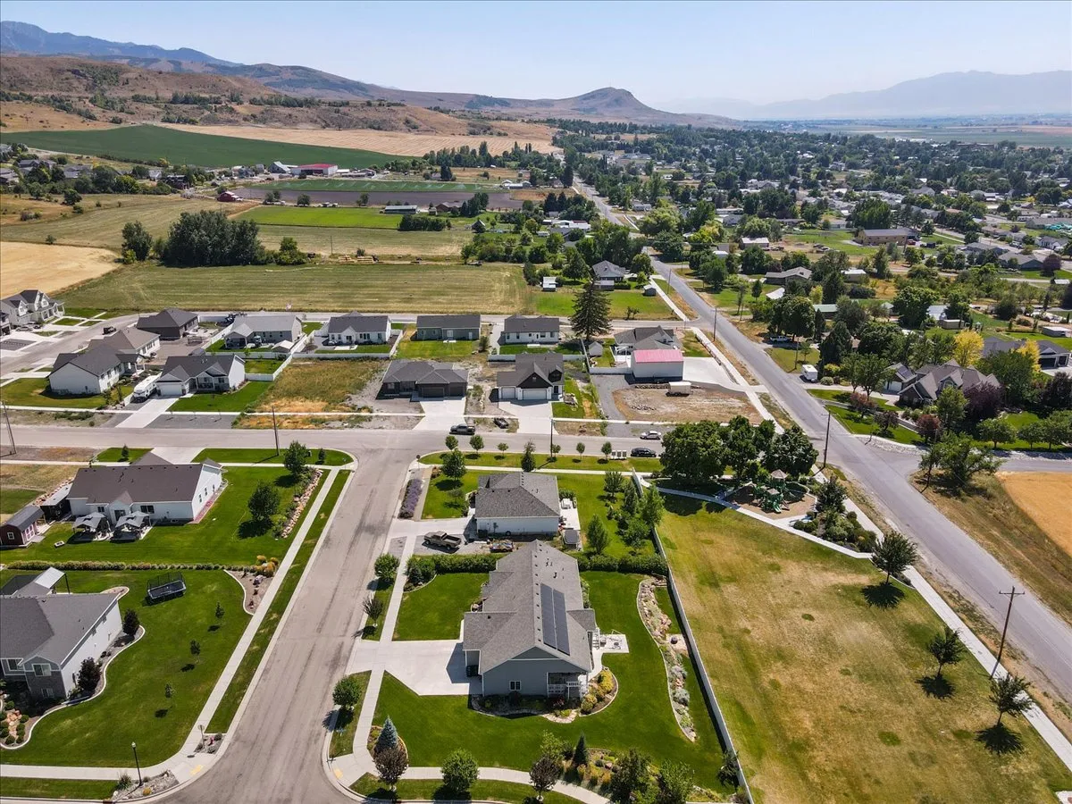 Aerial view of property and surrounding area with nearby suburban area and mountains