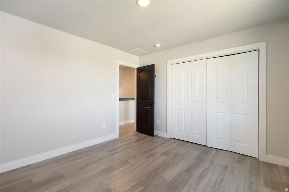 Unfurnished bedroom with light wood-style floors and a closet