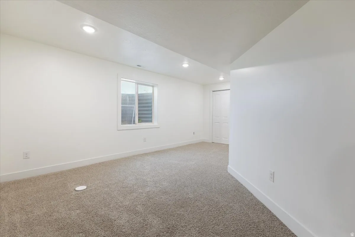 Carpeted spare room with recessed lighting and lofted ceiling