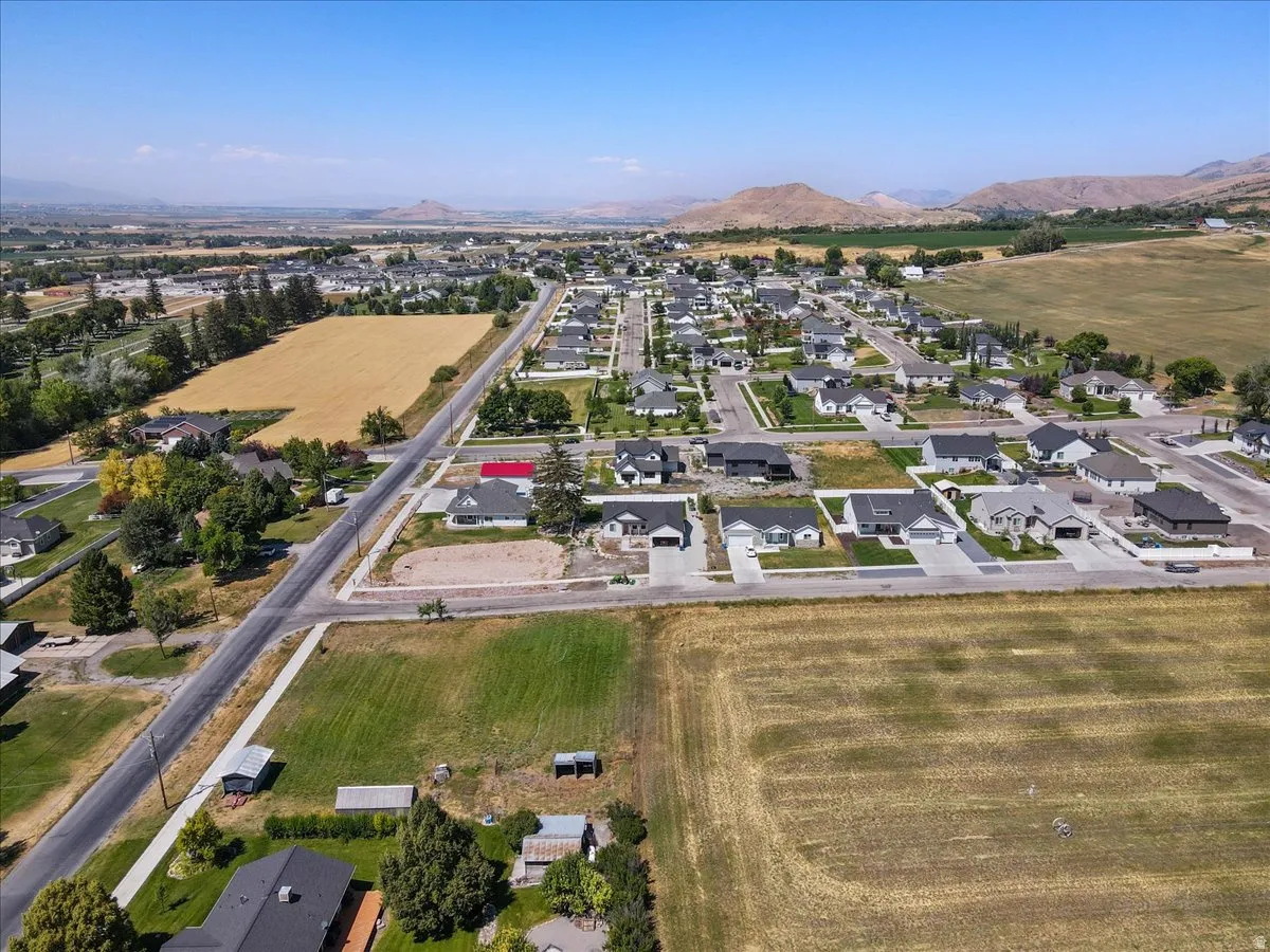 Aerial view of property and surrounding area with a mountain backdrop and nearby suburban area