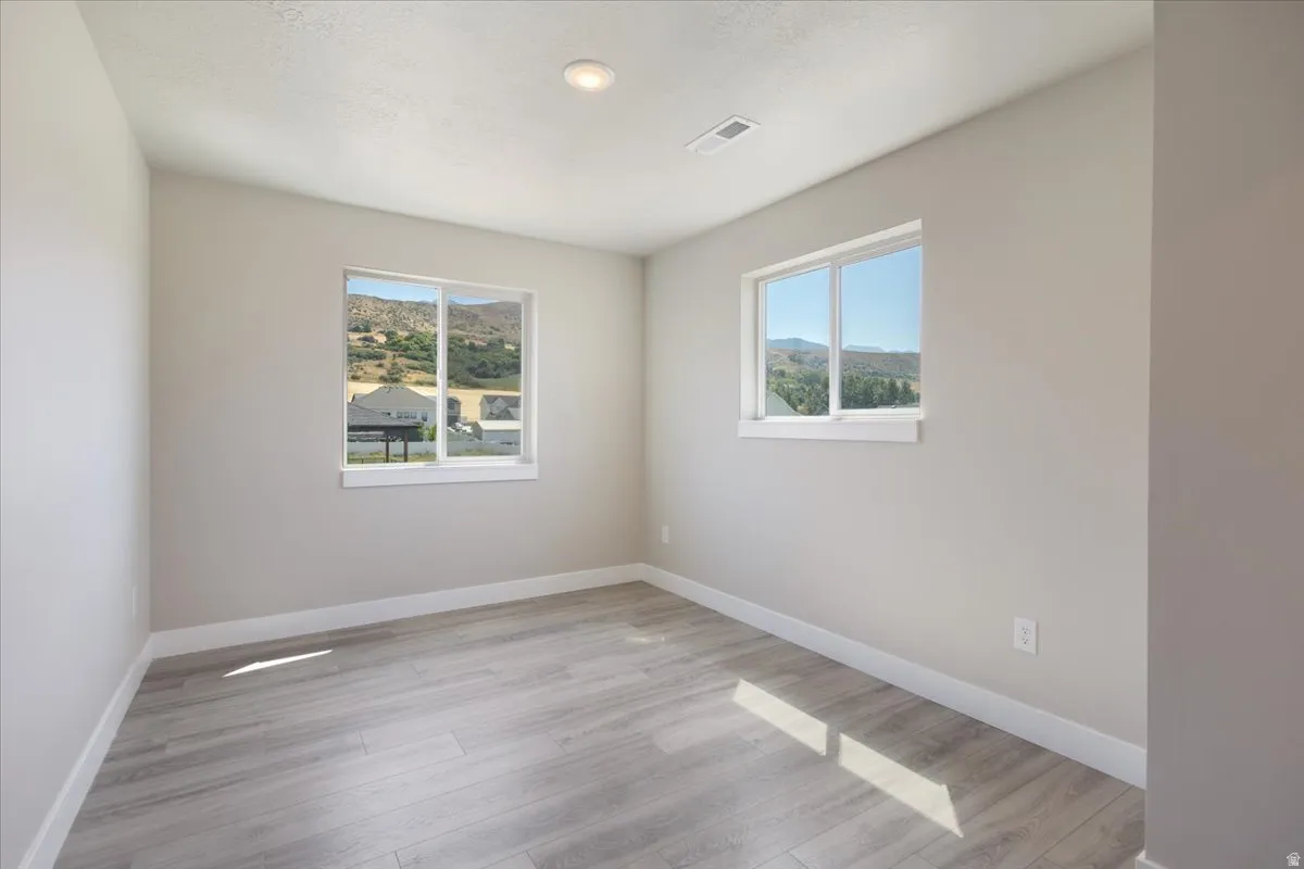 Empty room featuring baseboards and light wood-style flooring