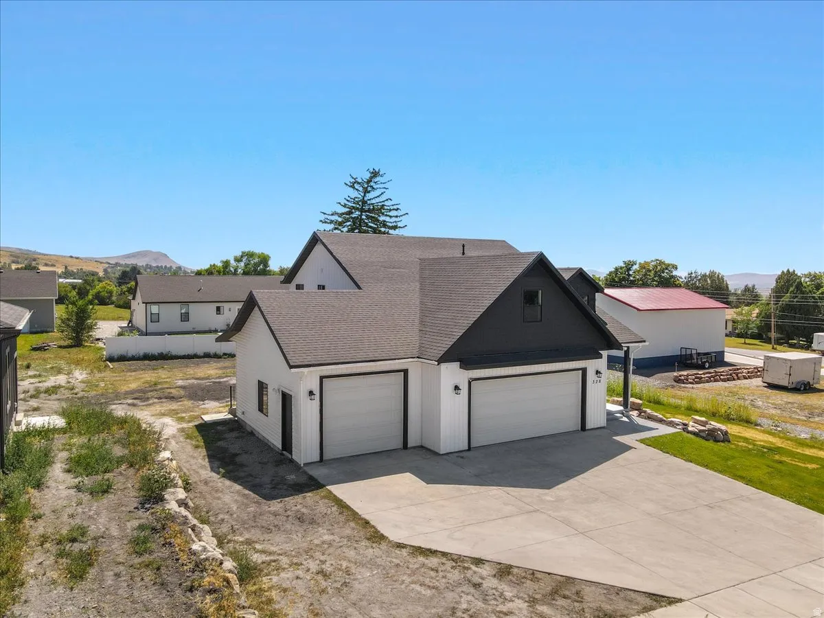 View of front of home featuring driveway, roof with shingles, and a mountain view