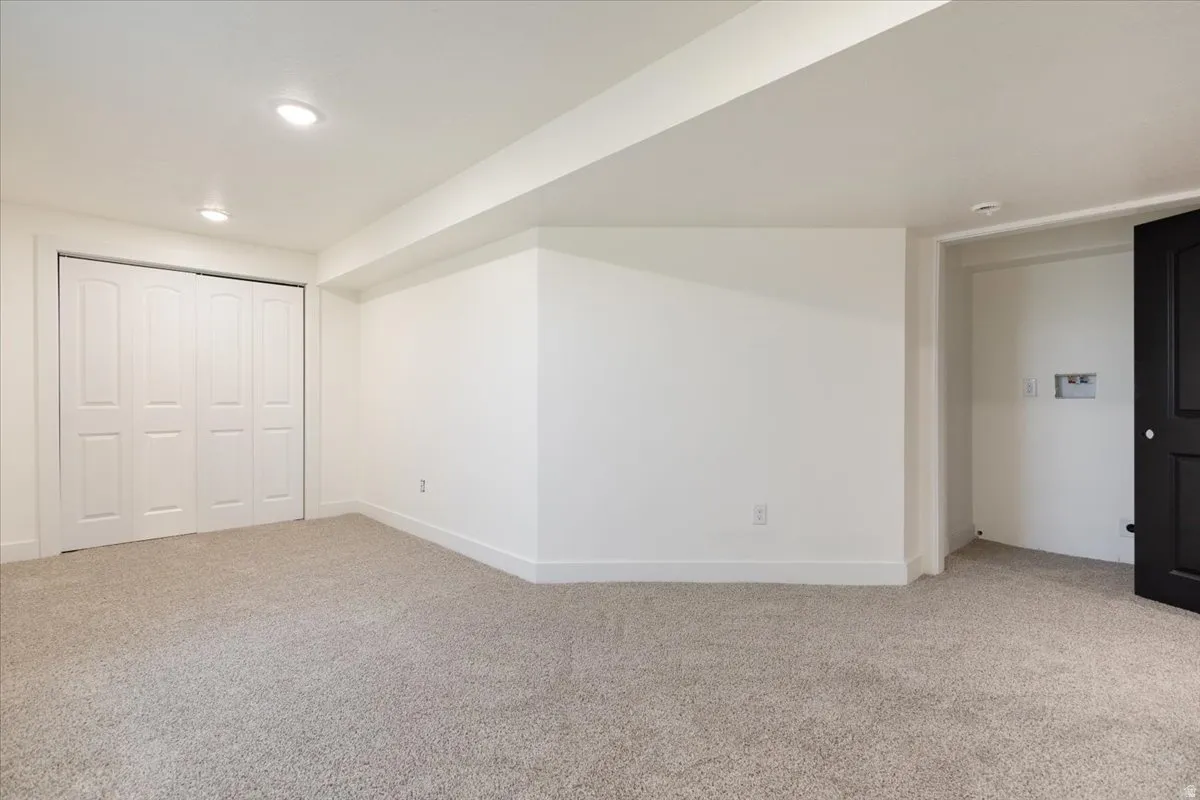 Additional living space featuring light colored carpet and recessed lighting