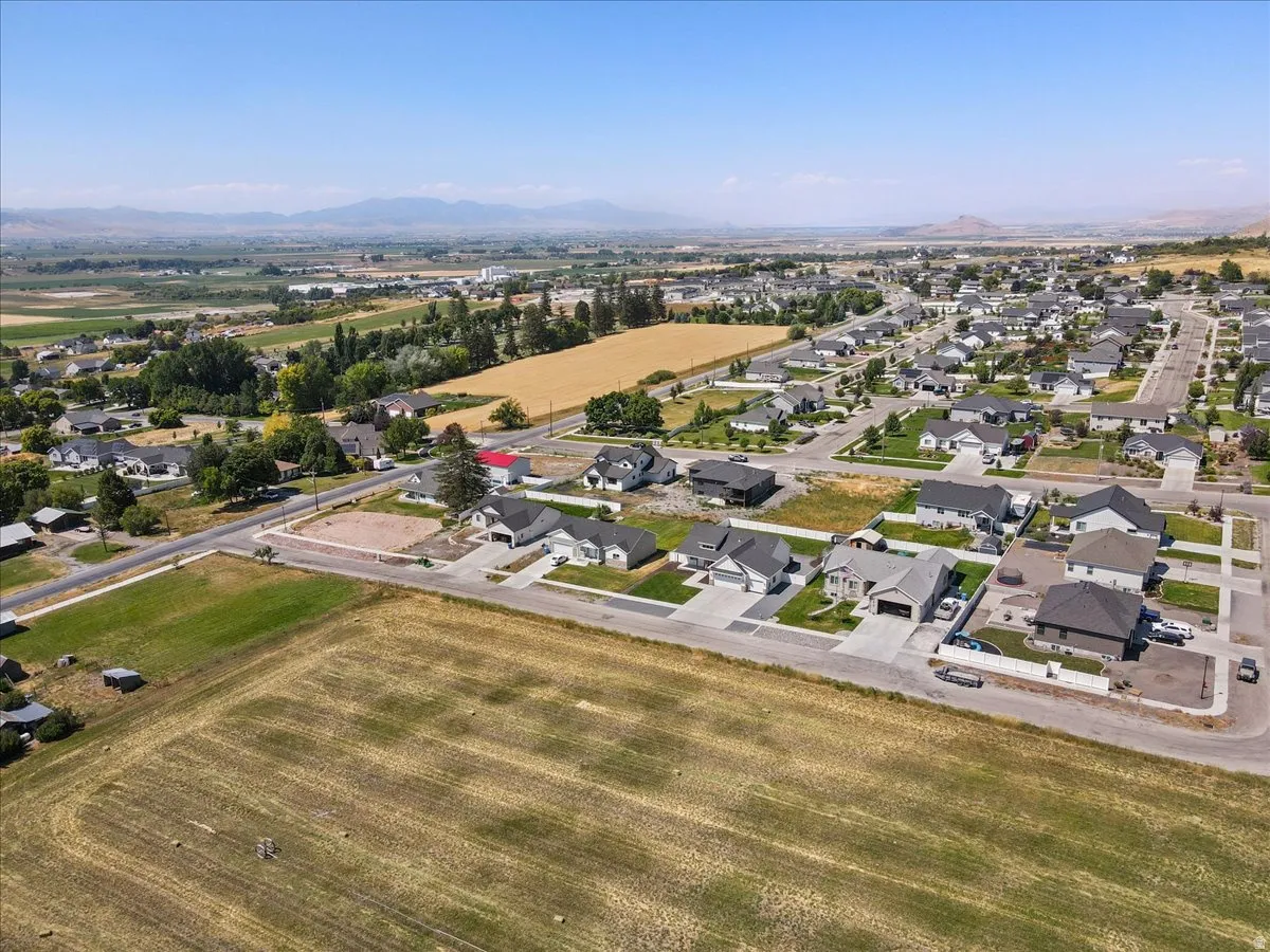 Aerial view of property and surrounding area with nearby suburban area and mountains