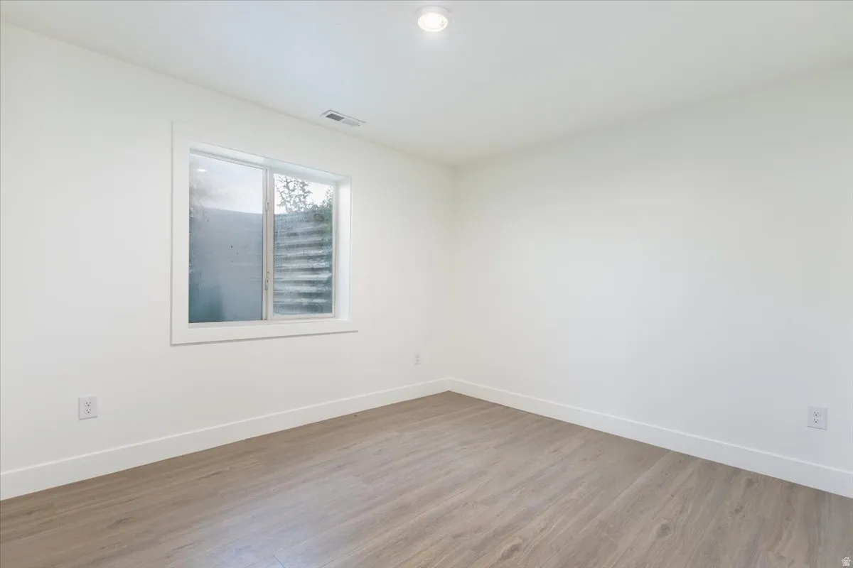 Spare room featuring wood finished floors and recessed lighting
