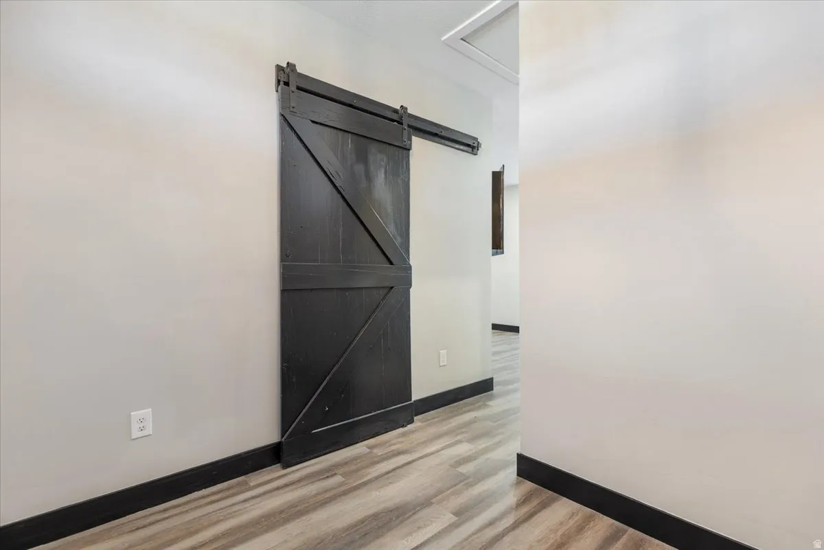 Spare room with light wood-type flooring and a barn door