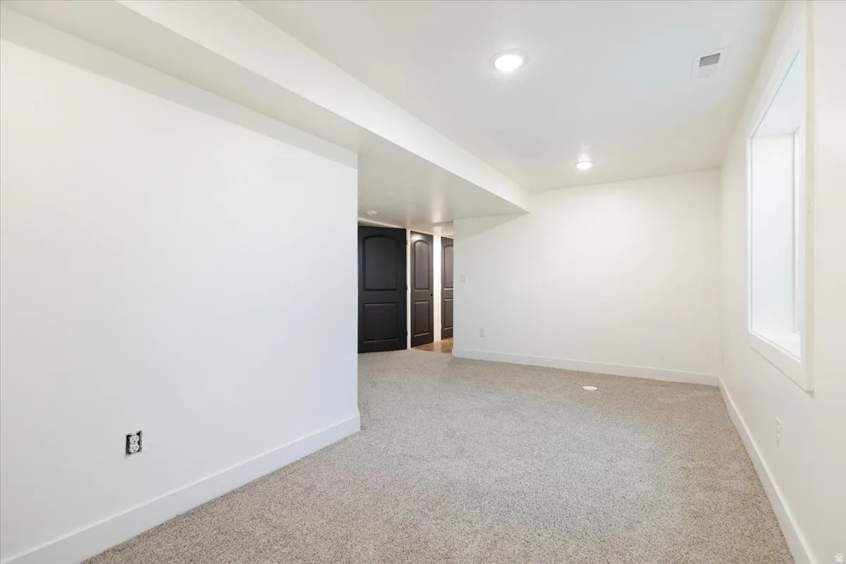 Spare room featuring light carpet and recessed lighting