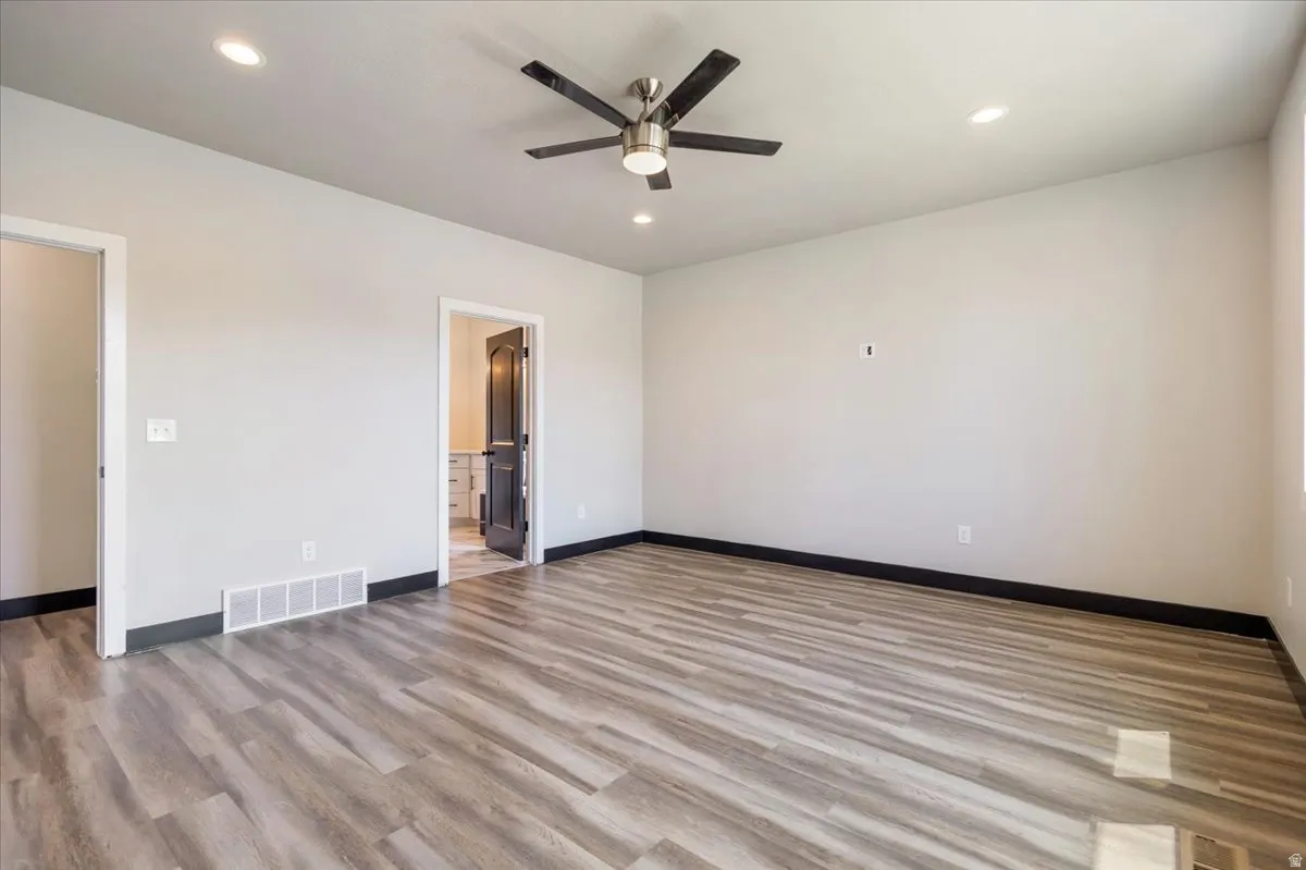 Empty room with light wood-style floors, recessed lighting, and ceiling fan