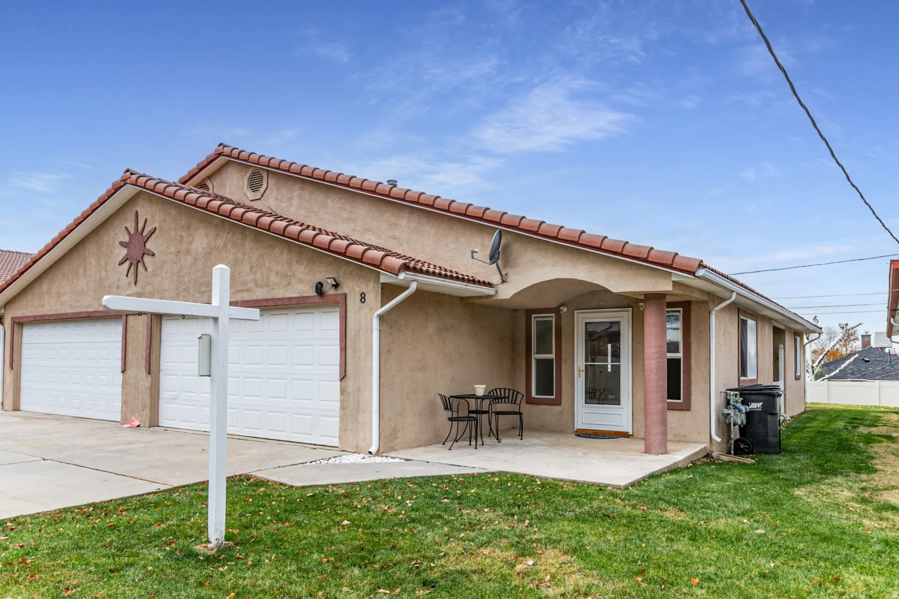 View of front of house featuring stucco siding, a patio, concrete driveway, and a front lawn