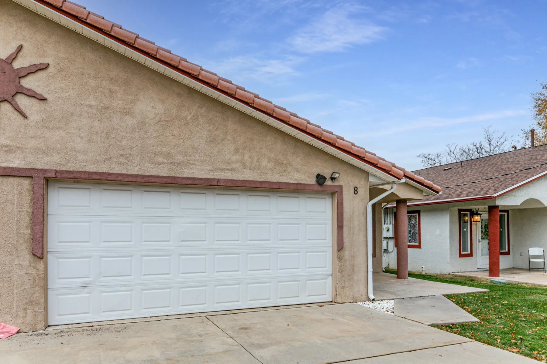 View of front of home featuring concrete driveway, stucco siding, and a tile roof