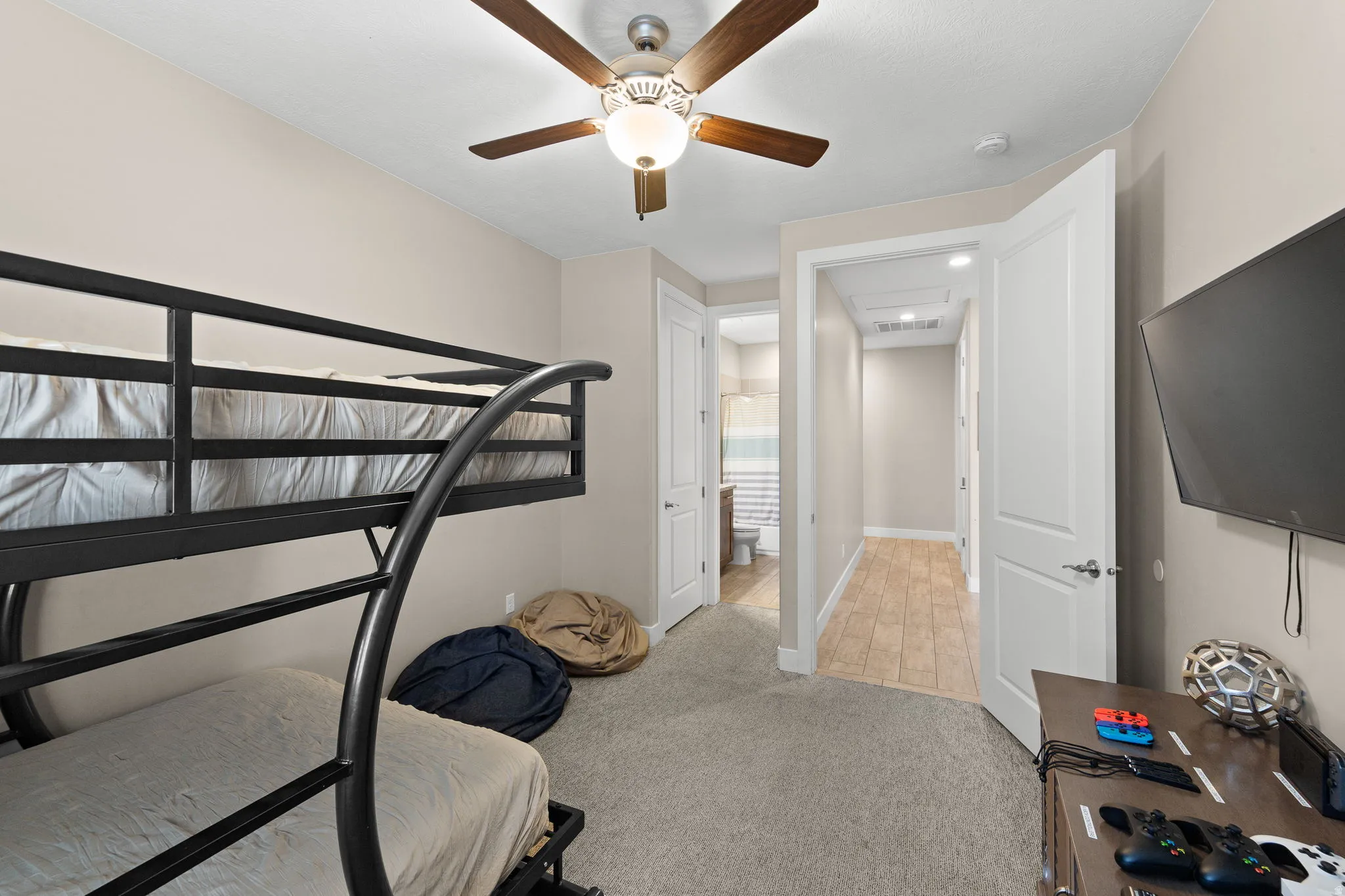 Bedroom with light colored carpet and ceiling fan