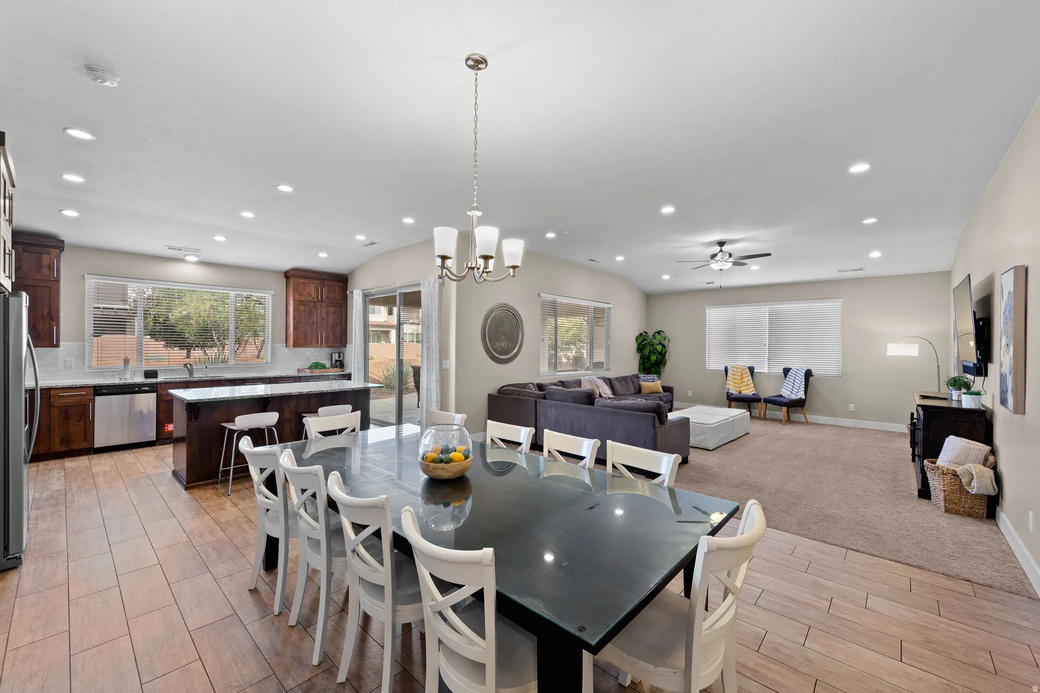 Dining space with a chandelier, recessed lighting, a ceiling fan, wood tiled floors, and light carpet