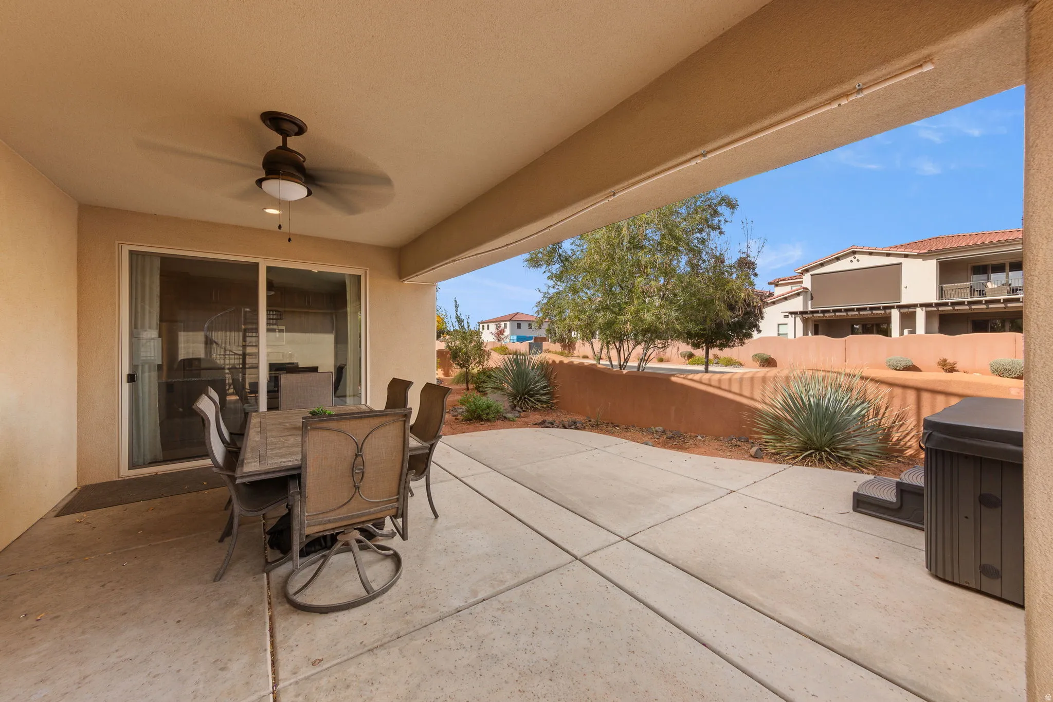 Fenced backyard featuring a patio area, outdoor dining space, and ceiling fan