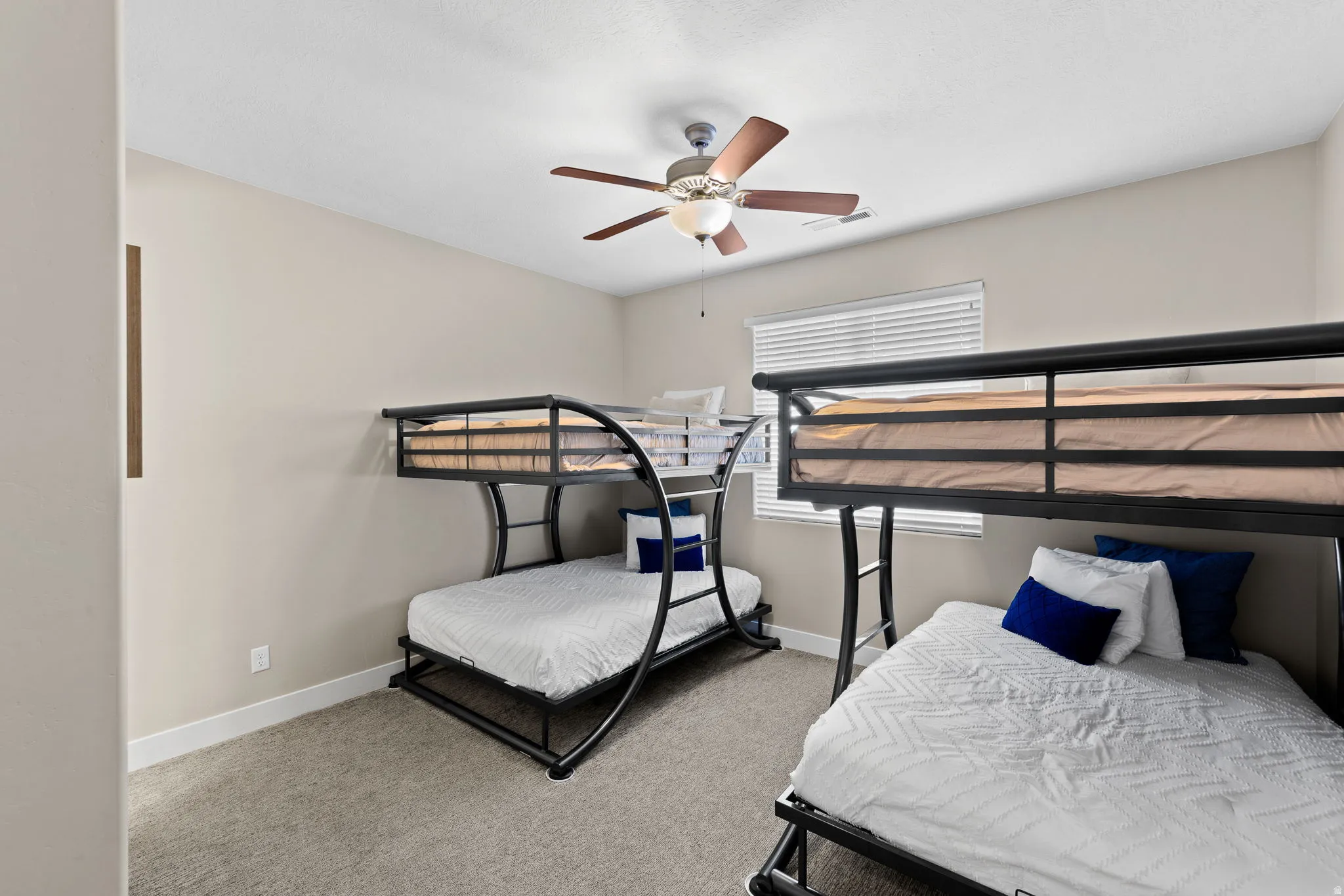 Bedroom featuring light colored carpet and a ceiling fan
