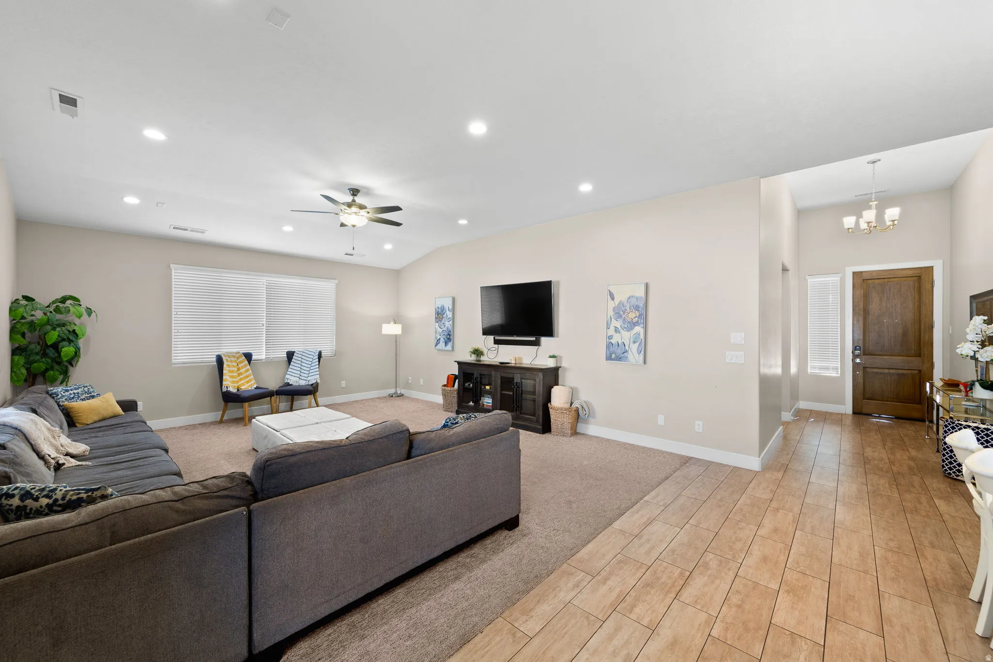 Living area with recessed lighting, light carpet, a chandelier, and light wood-type flooring