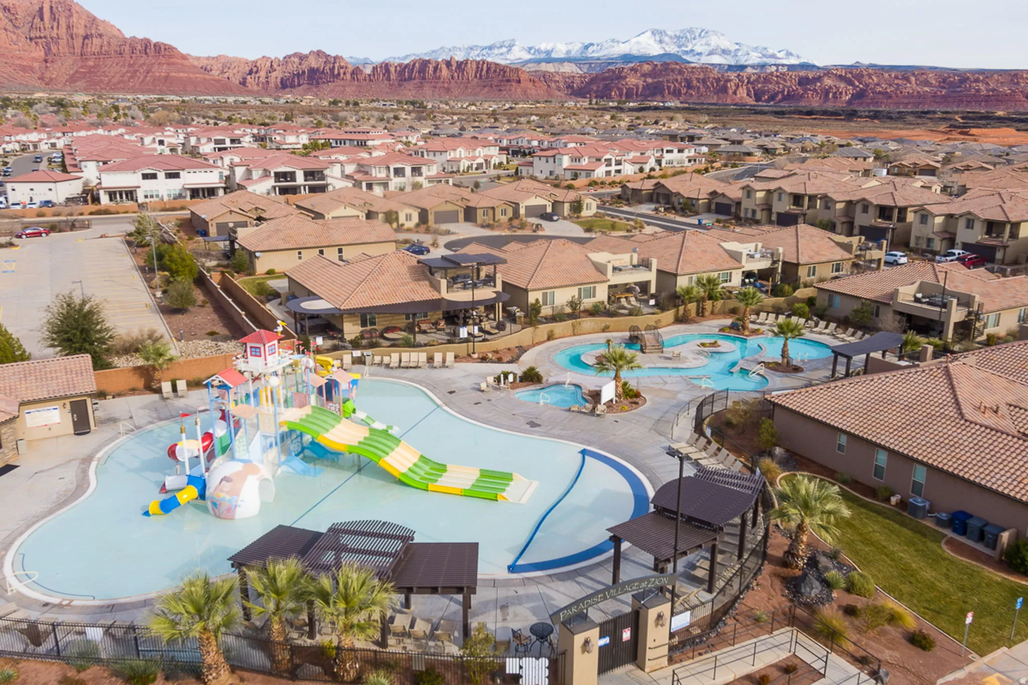 Aerial perspective of suburban area with a pool area and mountains