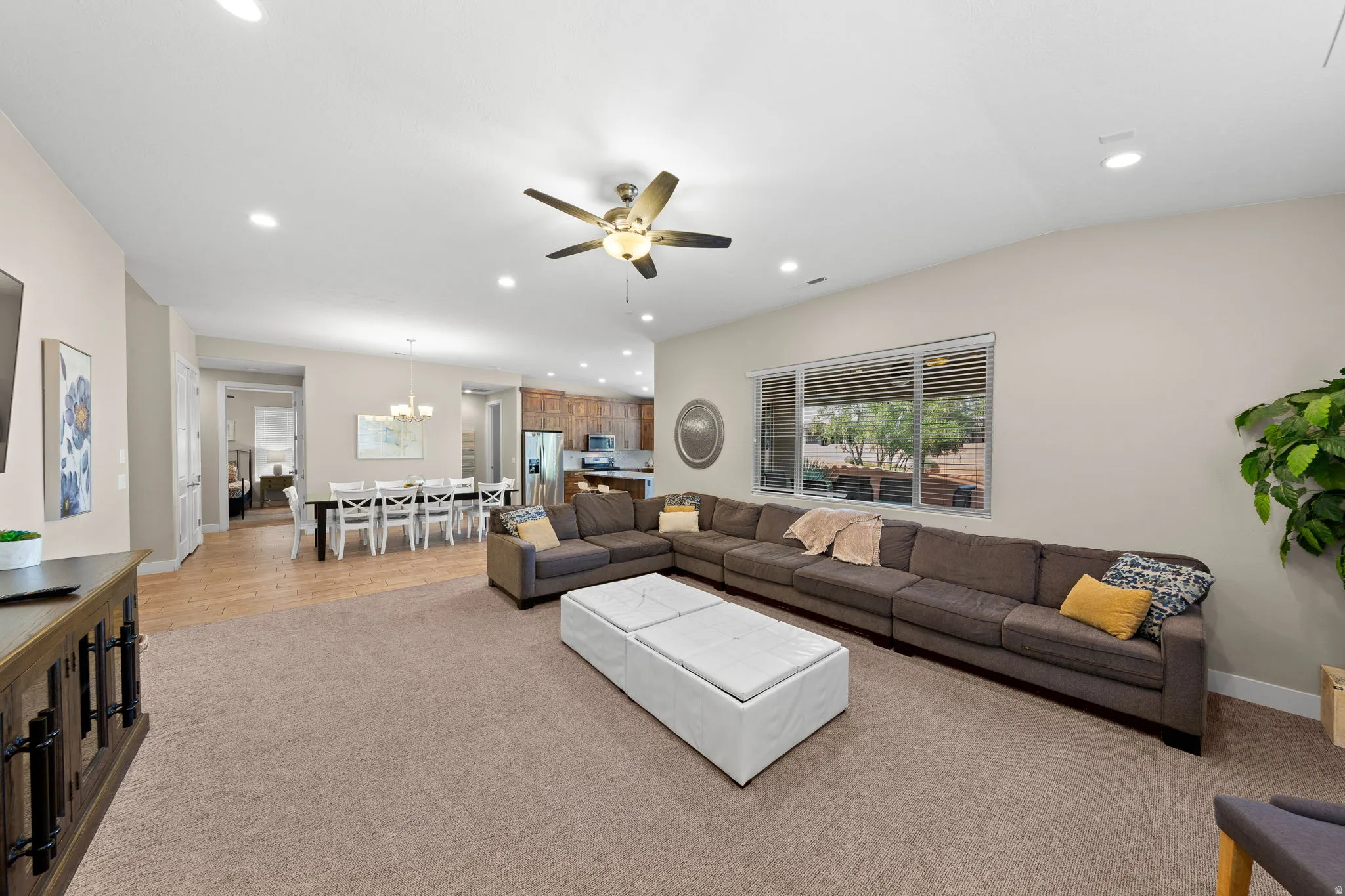 Living area featuring recessed lighting, a ceiling fan, light carpet, and a chandelier