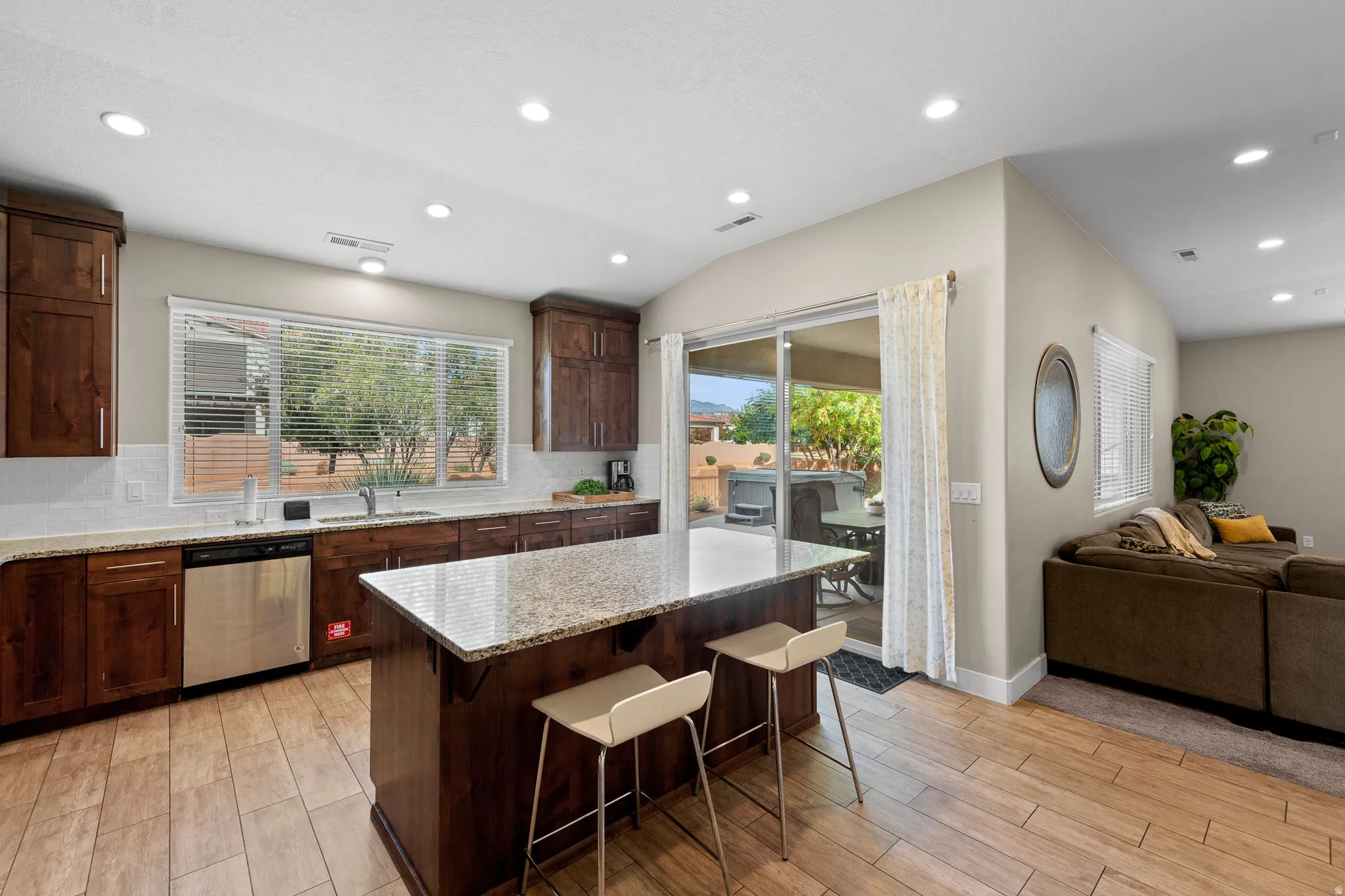 Kitchen featuring a kitchen breakfast bar, open floor plan, recessed lighting, light wood-style floors, and dishwasher