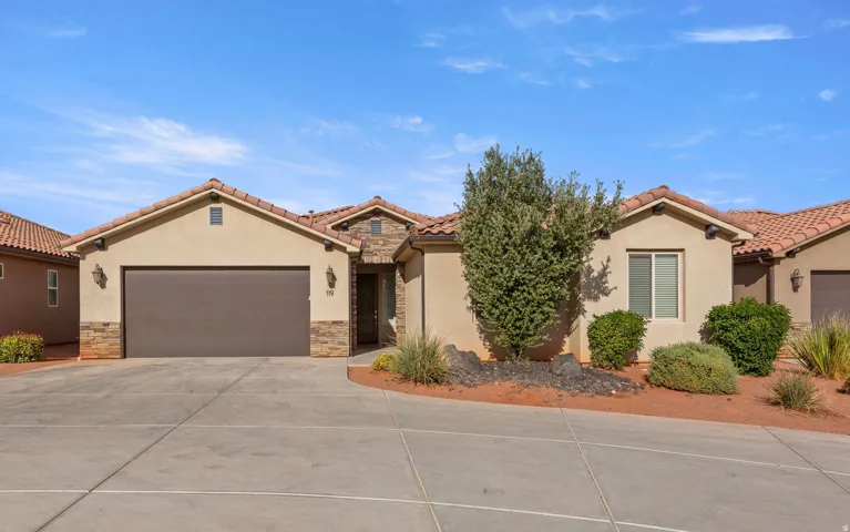 Mediterranean / spanish home featuring stucco siding, stone siding, concrete driveway, and a garage