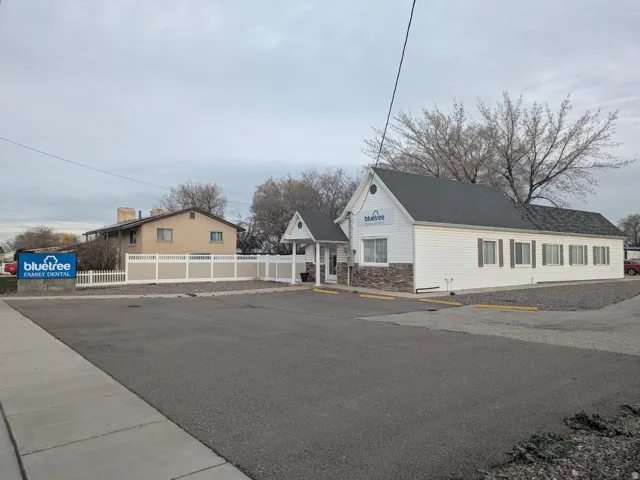 View of property exterior with stone siding and uncovered parking