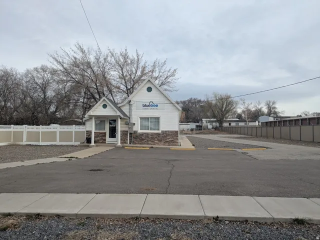 View of front of property featuring stone siding and uncovered parking