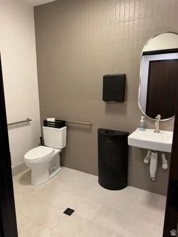 Bathroom with tile walls and light tile patterned floors