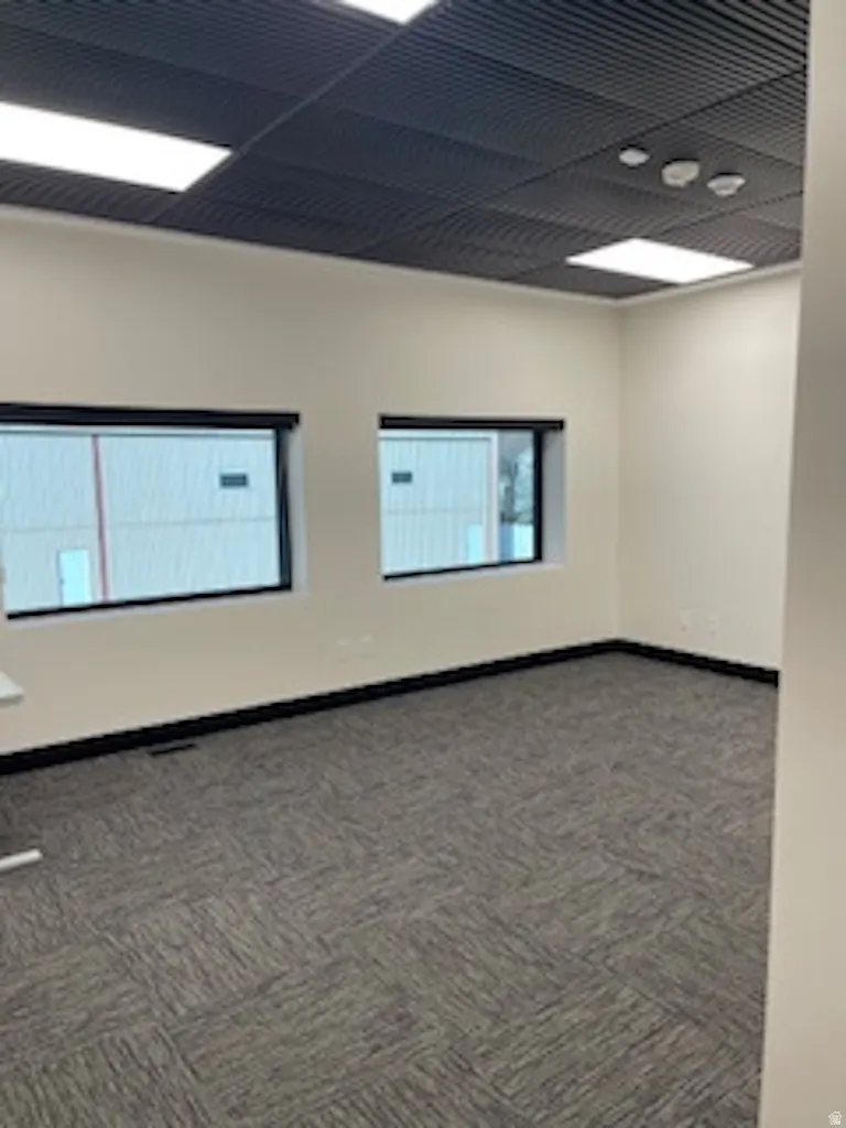 Spare room featuring dark carpet