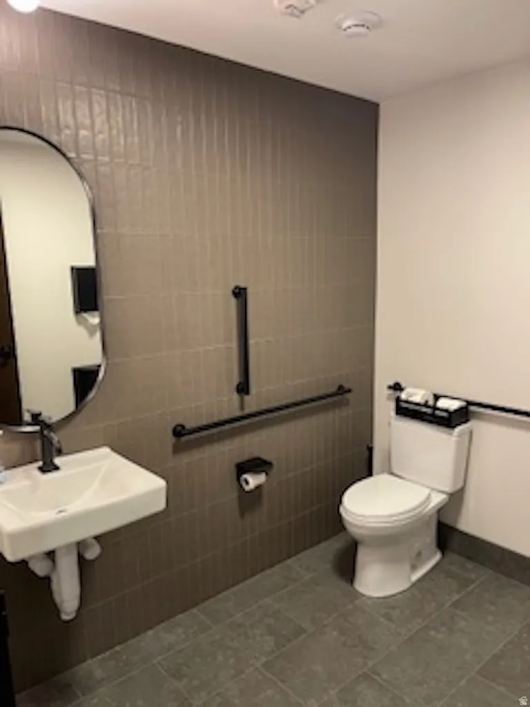 Bathroom with tile walls and dark tile patterned floors