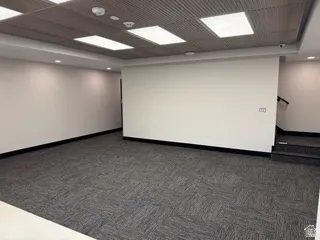 Unfurnished room with dark carpet and baseboards