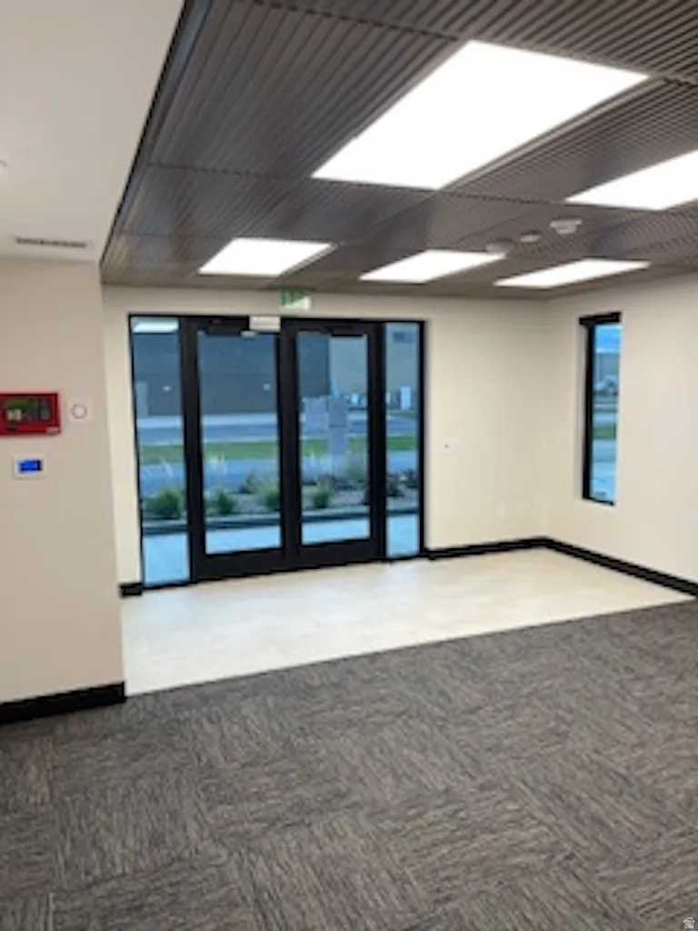 Unfurnished room with baseboards and light carpet