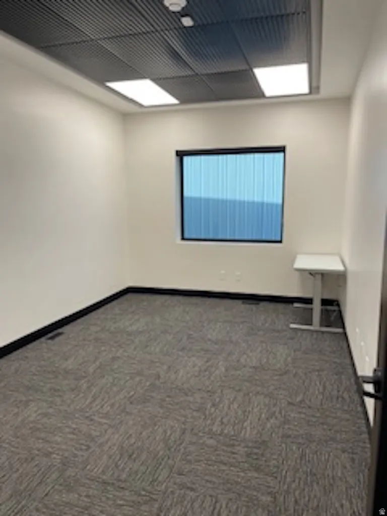 Carpeted empty room with baseboards