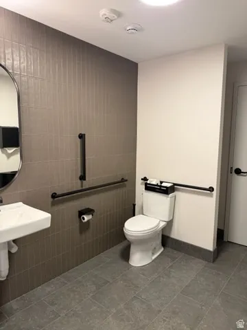 Bathroom with toilet and tile walls