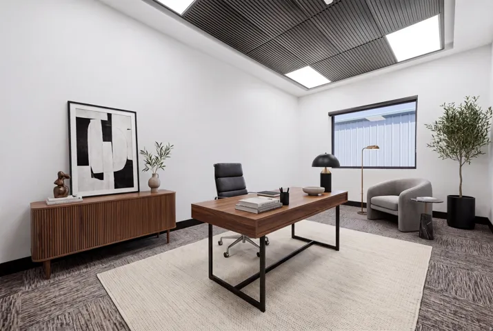Modern interior space featuring a grid ceiling with integrated lighting, a large window, and patterned carpet flooring