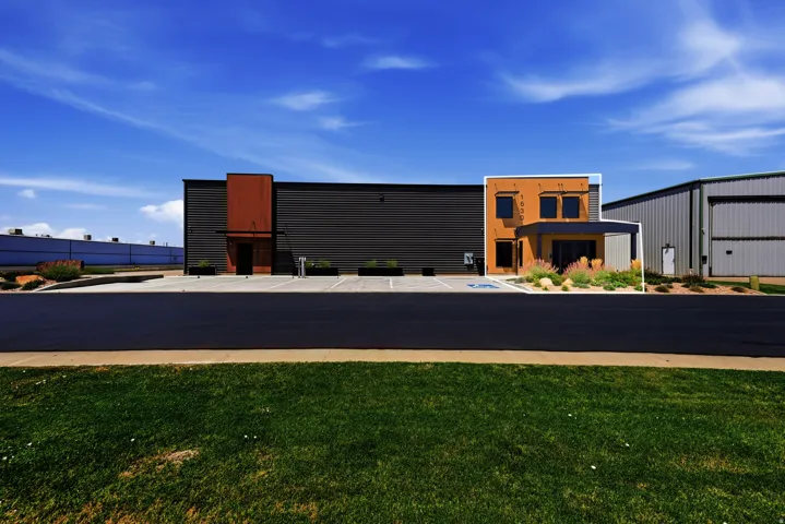 Modern commercial building featuring a dynamic facade with rust-colored paneling and stucco accents