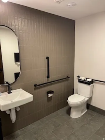 Bathroom with tile walls and dark tile patterned floors