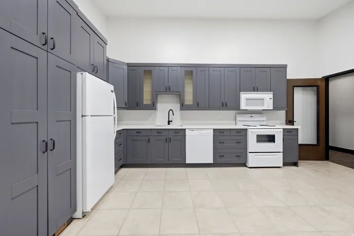 Kitchen featuring extensive gray cabinetry, white countertops, white subway tile backsplash, and white appliances
